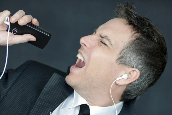 Businessman Wearing Headphones Sings Into Cell Phone — Stock Photo, Image