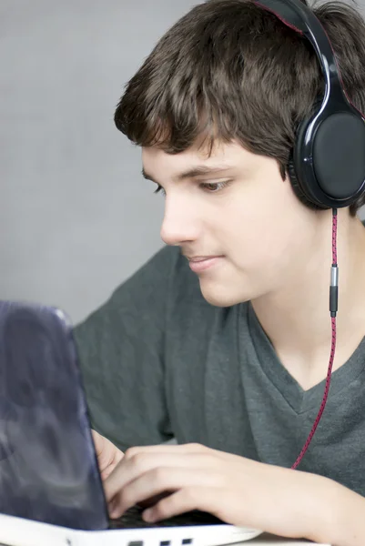 Auriculares que usan adolescentes funciona en la computadora — Foto de Stock