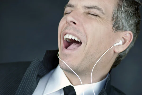 Empresario con auriculares canta — Foto de Stock