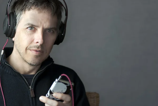 Headphone Wearing Man Looks at MP3 Player — Stok Foto