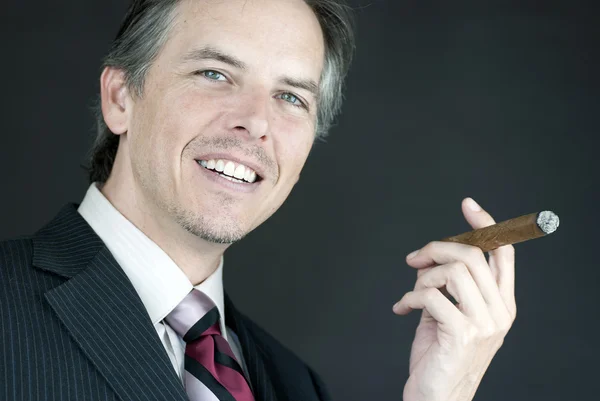 Selbstbewusster Geschäftsmann hält brennende Zigarre — Stockfoto