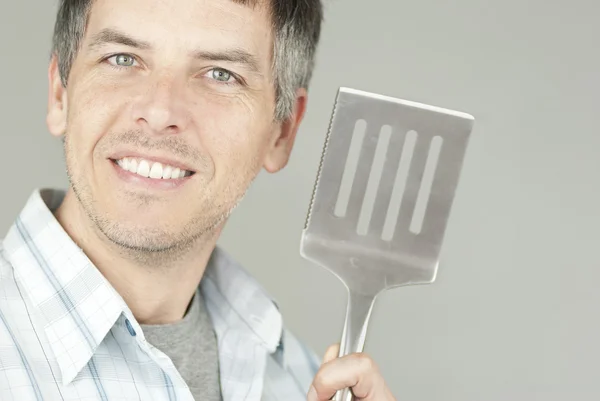 Man With BBQ Flipper Stock Image