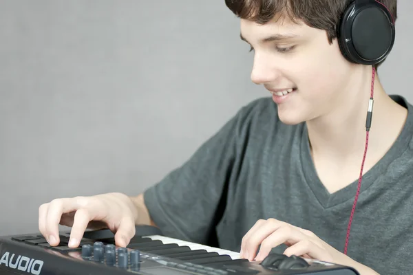 Fone de ouvido usando adolescente ajusta teclado — Fotografia de Stock