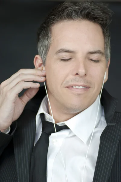 Selbstbewusster Geschäftsmann setzt Kopfhörer auf — Stockfoto