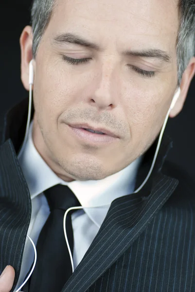 Biznesmen z zamkniętymi oczami noszenie słuchawek — Zdjęcie stockowe