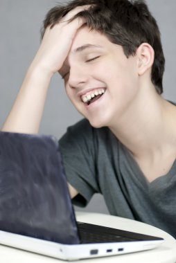 yorgun mutlu teen bilgisayarda çalışır.