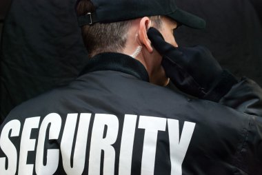 Security Guard Listens To Earpiece, Back of Jacket Showing clipart