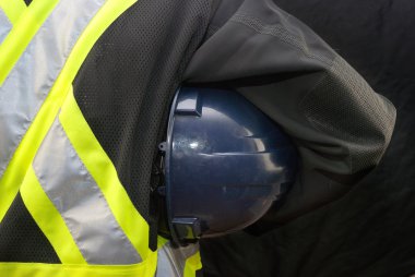 İnşaat işçisi kask kol altında tutar.