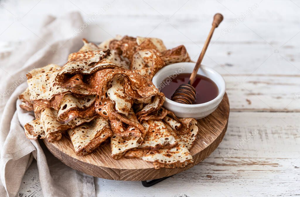 Stack of traditional russian pancakes blini on wooden background. Maslenitsa traditional Russian festival meal.