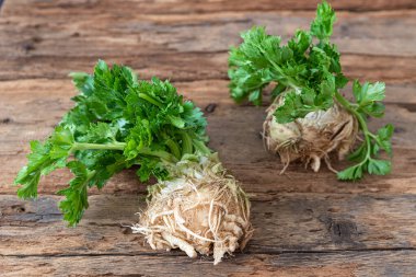 Tahta üzerinde yeşil yapraklar olan kereviz kökleri