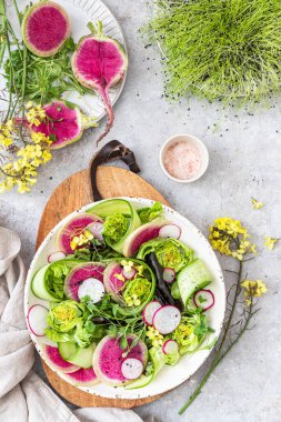 Turp, salatalık, marul ve hardal çiçekli bahar salatası.