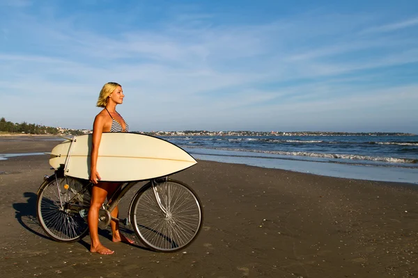 Mujer en bicicleta con surf — Foto de Stock