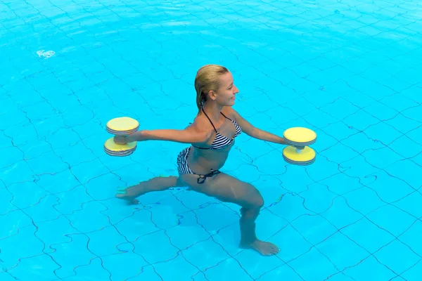 Mujer se dedica aqua aeróbic en el agua — Foto de Stock