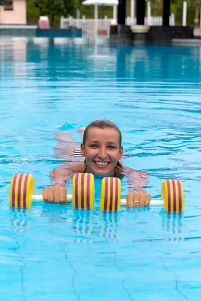 Aqua aerobics, vrouw in water met halters — Stockfoto