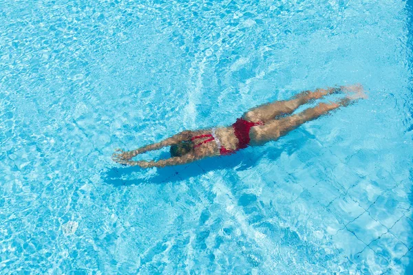 Femme avec maillot de bain nageant sur une piscine d'eau bleue — Photo