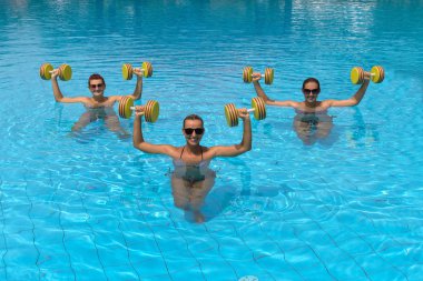 aqua dumbbell ile egzersiz yaparak mutlu aktif fitness insanlar