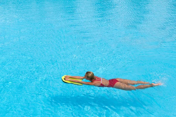 Nadador durante a prática com placa de poliespuma para natação — Fotografia de Stock