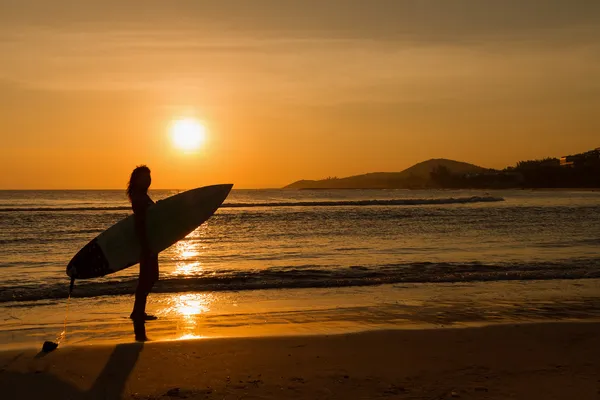 Visão traseira da bela menina surfista sexy em biquíni com prancha de surf branca em uma praia ao pôr do sol ou ao nascer do sol — Fotografia de Stock