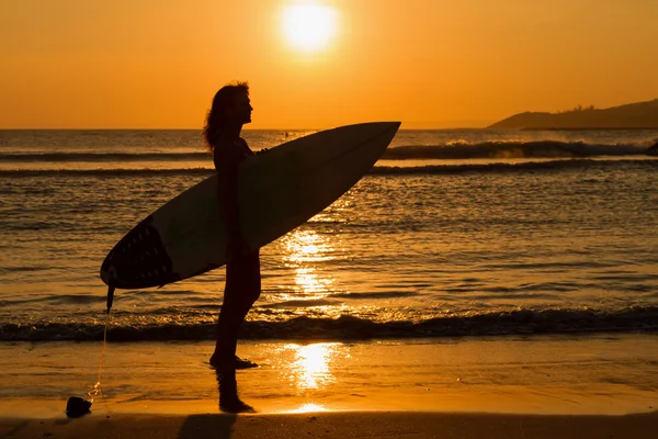 Vue arrière d'une belle jeune femme surfeuse sexy en bikini avec planche de surf blanche sur une plage au coucher du soleil ou au lever du soleil — Photo