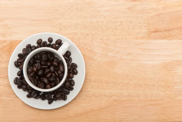 Taza de café con granos de café derramados, fondo — Foto de Stock