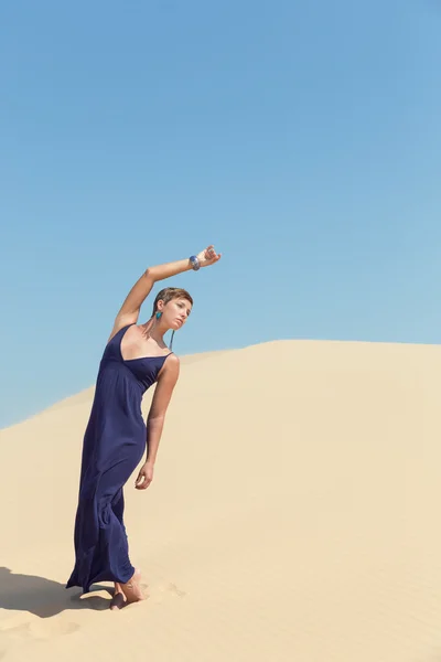 Beautiful woman in blue dress in sand dune — Stock Photo, Image