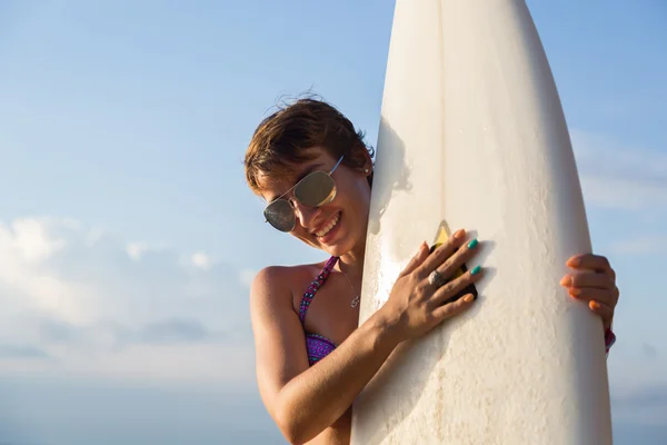 日落或日出时带着白色冲浪板穿着比基尼的漂亮性感女冲浪女郎的背影 — 图库照片