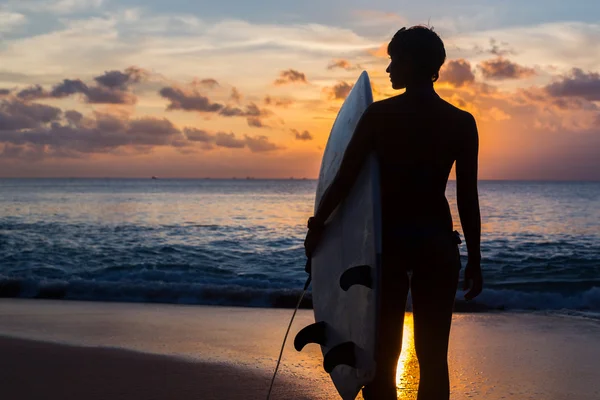 Nő szörfös, szörf, trópusi tengerparton naplementekor — Stock Fotó