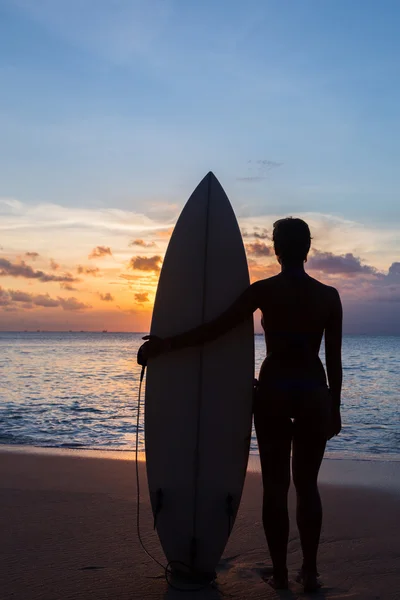 Mujer surfista con tabla de surf en la playa tropical al atardecer —  Fotos de Stock