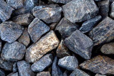 Büyük gri çakıl taşları. Arkaplanda granit kayalar var..