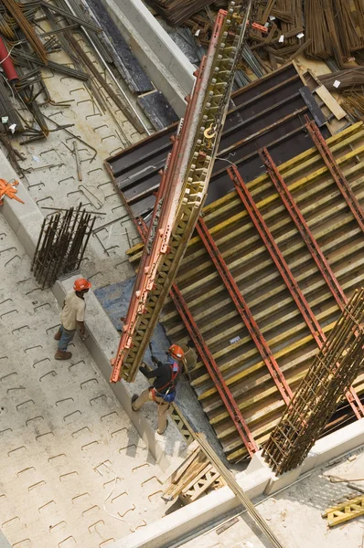 Trabalhadores e equipamentos de elevação no local de construção — Fotografia de Stock