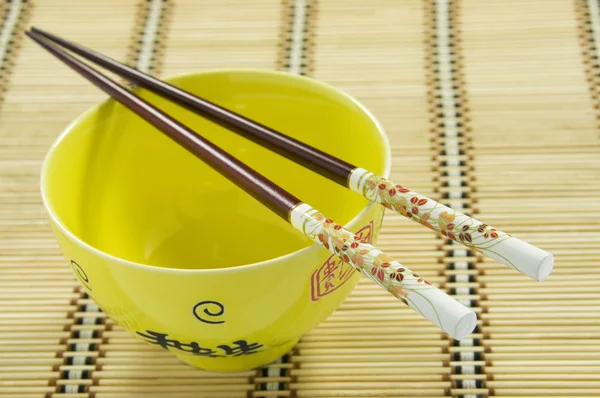 Chinese Rice Bowl and Decorative Chopsticks on Rattan Mat. Chinese New Year — Stock Photo, Image