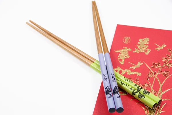 Chinese Snake and Dragon Chopsticks With Red Chinese Money Wallet. Chinese New Year. — Stock Photo, Image