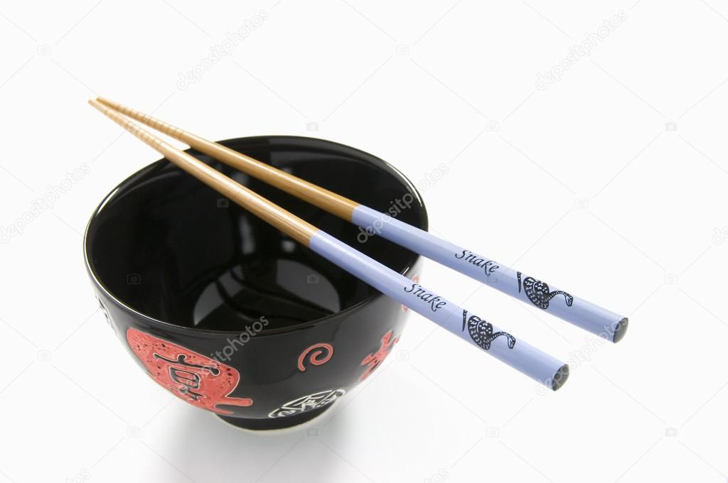 Chinese Rice Bowl and Decorated Snake Chopsticks on White Background. Chinese New Year