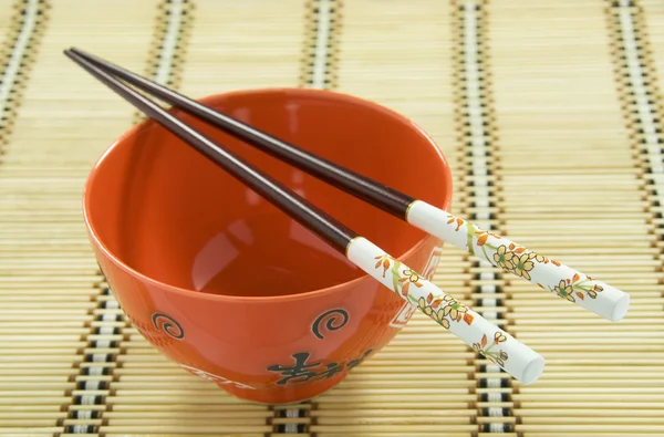 Chinese Rice Bowl and Decorated Chopsticks on Rattan Mat. Chinese New Year — Stock Photo, Image