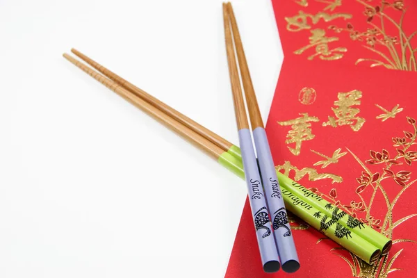 Chinese Snake And Dragon Chopsticks With Red Money Wallet On White Background. Chinese New Year. Year Of The Snake — Stock Photo, Image