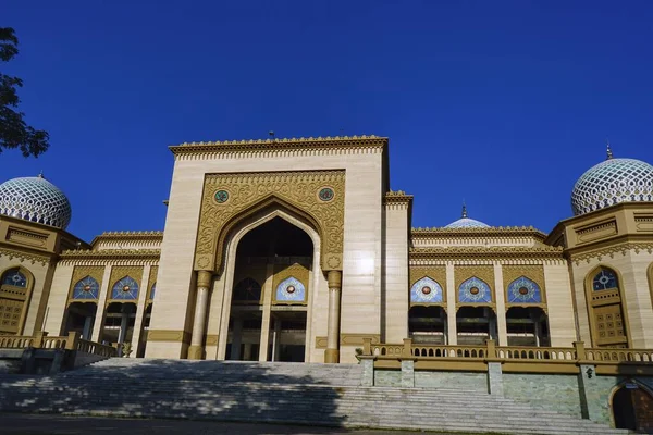 Beautiful Islamic Center Mosque in Lhokseumawe with blue sky. The building covering an area of 16,475 m2 which is dominated by golden color is the grandest mosque in Lhokseumawe