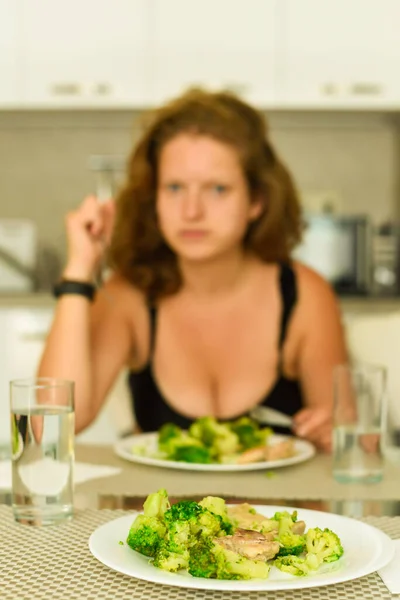 Teller mit Brokkoli, Mädchen im Hintergrund beim Mittagessen — Stockfoto