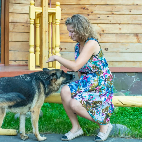 Köpeğiyle evin bahçesinde Alman çoban köpeği olan kız.