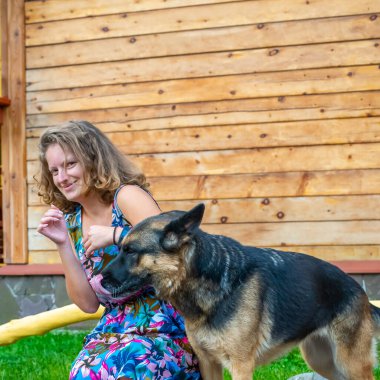 Köpeğiyle evin bahçesinde Alman çoban köpeği olan kız..