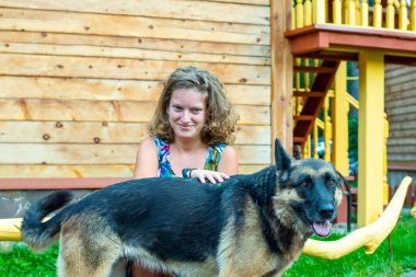 Köpeğiyle evin bahçesinde Alman çoban köpeği olan kız..
