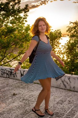 Gün batımında dans eden genç bir kadın.