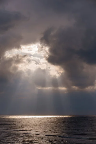 The suns rays passing through the storm clouds over the sea — Stock Photo, Image
