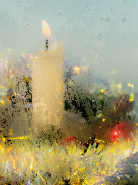 Weihnachtskerze Kerzenständer Mit Beeren Und Lametta Durch Ein Gefrorenes Fenster — Stockfoto