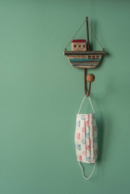 Tıbbi maske, askısına denizcilik tarzında tutunur. Seyahat planlama kavramı.