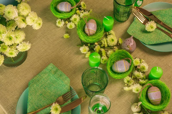 Gedeckter Tisch mit Osterdekoration - Eier in Nestern und Blumen. — Stockfoto