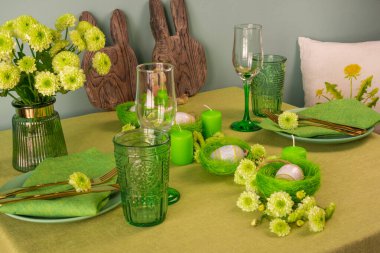 Paskalya dekorasyonlu bir masa hazırla. Yuvalarda ve çiçeklerde yumurtalar..