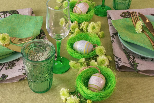 Gedeckter Tisch mit Osterdekoration - Eier in Nestern und Blumen. — Stockfoto