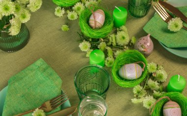 Paskalya dekorasyonlu bir masa hazırla. Yuvalarda ve çiçeklerde yumurtalar..