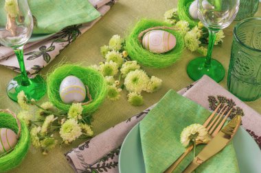 Paskalya dekorasyonlu bir masa hazırla. Yuvalarda ve çiçeklerde yumurtalar..