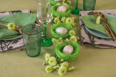 Paskalya dekorasyonlu bir masa hazırla. Yuvalarda ve çiçeklerde yumurtalar..